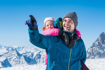Young father enjoying with daughter a sunny winter day.の写真素材
