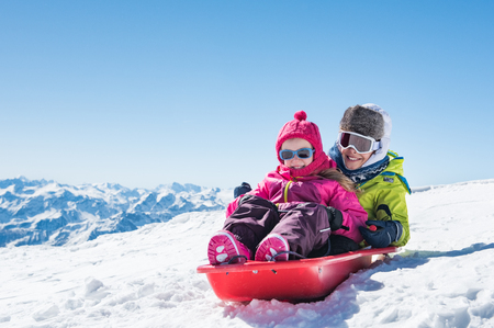 Happy little brother and cute sister enjoying sleigh ride.