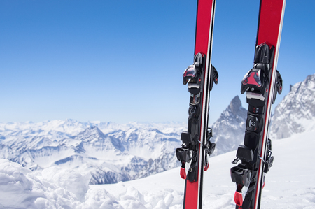 Pair of red skis standing in snow with copy space.の写真素材