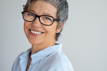 Portrait of senior woman with eyeglasses looking at camera isolated on gray background.の写真素材