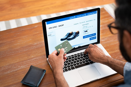 Man using credit card to do shopping online with laptop. Mature man buying formal shoes online. Man making online payment with credit card and laptop.の写真素材