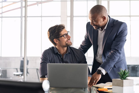 Senior and junior businessman discussing during their meeting. African american executive working...