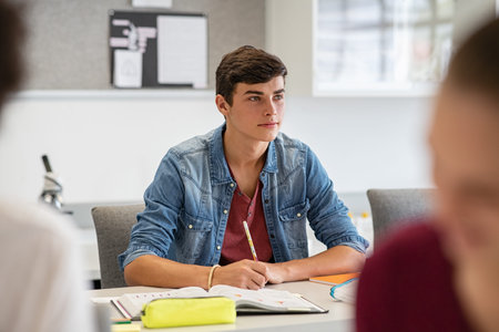 Young college student listening carefully while in lecture. University young man studying and...
