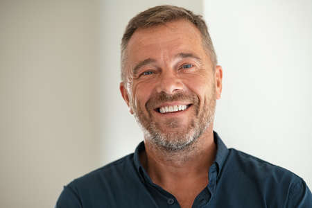 Handsome businessman smiling and looking at camera. Portrait of carefree mature man with copy space. Successful mid adult business man laughing.の写真素材