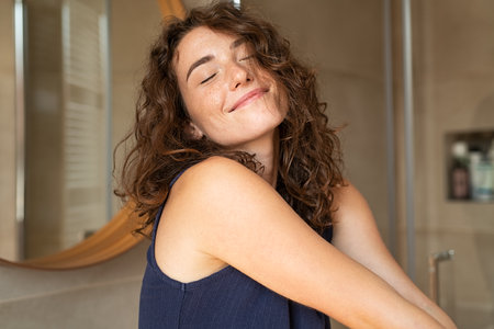 Happy young woman feeling relaxed with eyes closed. Smiling woman stretching with hands forward feeling fresh on a bright morning. Beautiful girl stretch herself in the morning ..の写真素材