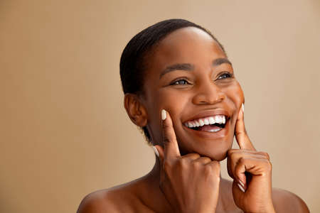 Beautiful middle aged woman smiling after face treatment at salon.の写真素材