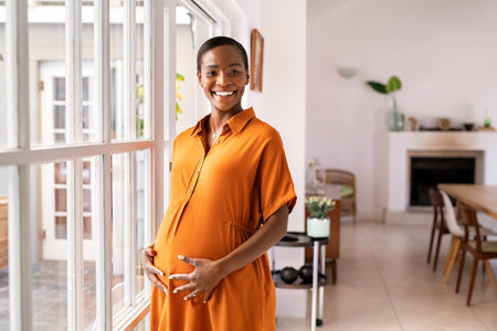 Happy middle aged pregnant woman with big tummy relaxing at home. Portrait of mature pregnant...