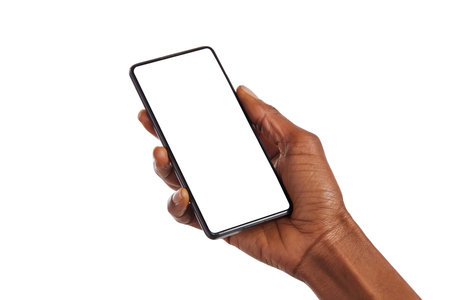 Close up of black woman hand holding smartphone against white background with copy space. African american woman hand holding cellphone with blank screen. Showing empty screen of mobile phone isolated.の写真素材