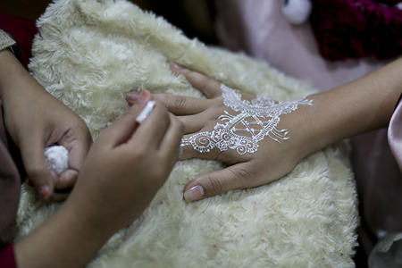 Mehndi artist drawing mehndi design women handsの写真素材