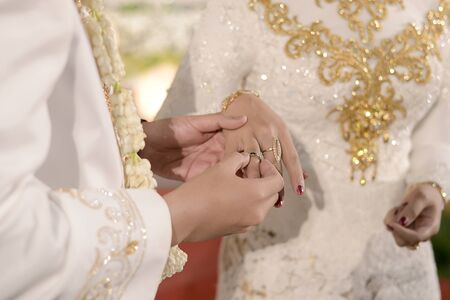 Pasang Cincin on Javanese Wedding. Traditional Javanese Groom Puts a Ring On The Brideの写真素材