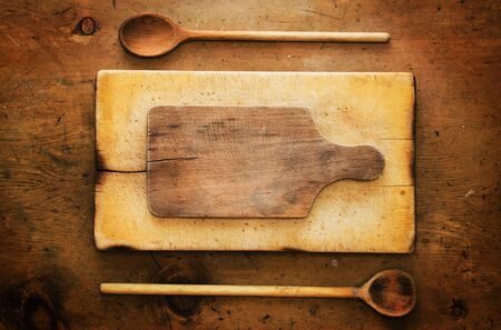 Old wood table with wooden spoons and boards makes a frame for text in rustic vintage style. Top view. Retro concept background.の写真素材