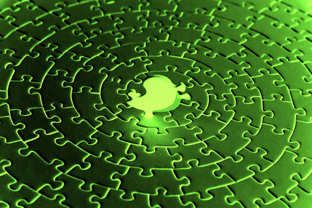 abstract of a jigsaw in infrared colors with the last piece upstanding - pieces fitting together in form of a spiralの写真素材