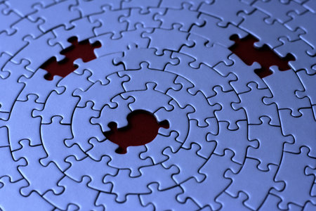 three missing pieces in a blue jigsaw - focus is on the center holeの写真素材