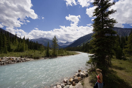 young woman at the bank of a river with glacial water - in the rockies, canada - の写真素材