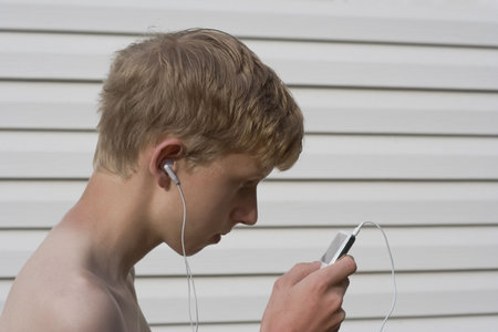 teen listening to music - looking on his mp3 player