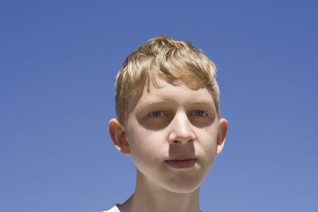 teenage boy portrait - against a blue sky の写真素材
