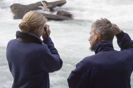Father and daughter watching salmon run in Fraser River - Rearguard Falls Provincial Park, Canadian Rockies, British Columbiaの写真素材
