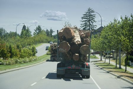 Trucks in Motion carrying a Load of Logs - Vancouver Island, British Columbia, Canadaの写真素材