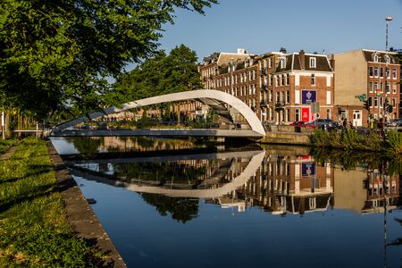 Amsterdam Holland June 2019 bridge over water near western gas factory at the haarlemmerdijk refecting in the waterのeditorial素材
