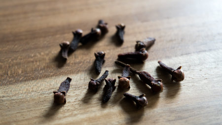Dry spice cloves isolated on wooden backgroundの写真素材