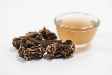 Herbal drink: Indian sarsaparilla roots and juice on white background
