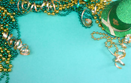 Image for Saint Patricks Day on March 17th. A border of green and gold ribbons and beads and a sparkly leprechaun  hat on green. Copy space.の写真素材