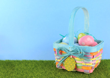 Cute Easter image with green grass and blue sky with colorful easter basket full of sparkly eggs....