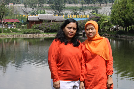 Lembang, Indonesia - Jan 22, 2023 : Two muslim women standing in front of a lake.のeditorial素材