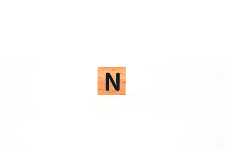 A wooden block with the letter N isolated on a white background for education or craft projectsの写真素材