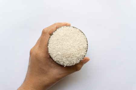Asian man holding Indonesian native Kalimantan Indonesian raw rice in cans isolated on white...