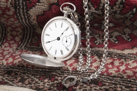 Elegant silver pocket watch over a carpetの写真素材