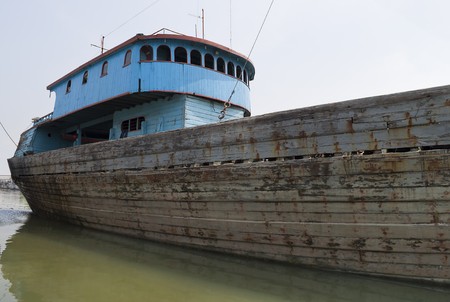 Blue rusty vessel in a canal in Jakarta harbor の写真素材