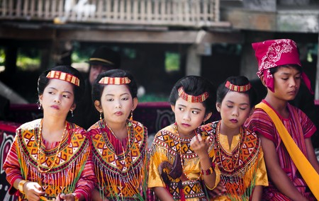 Children dressed with traditional toraja clothes during a funeral ritual in Indonesian village on 15th August 2010のeditorial素材