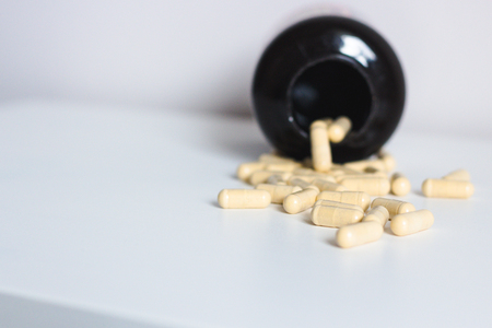 Pills capsules with bottle on white backgroundの写真素材