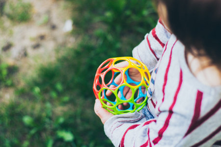 Little toddler girl holding colorful ball