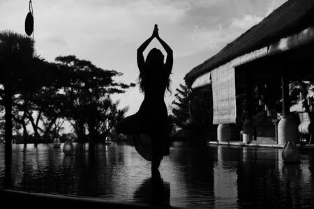 woman yoga workout out on the sea at sunriseの写真素材