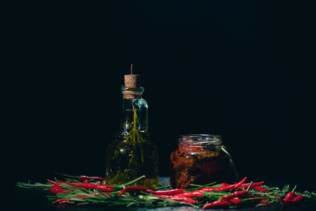 Olive oil, tomato and chilli on tableの写真素材