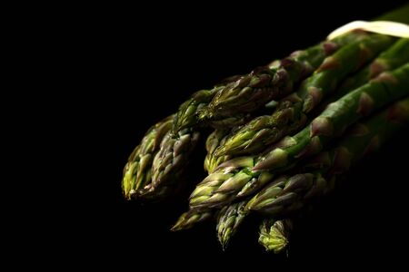 A bunch of fresh organic asparagus on a black backgroundの写真素材