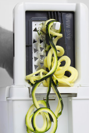 Abstract image of a courgette being sliced on a spiralizer machineの写真素材