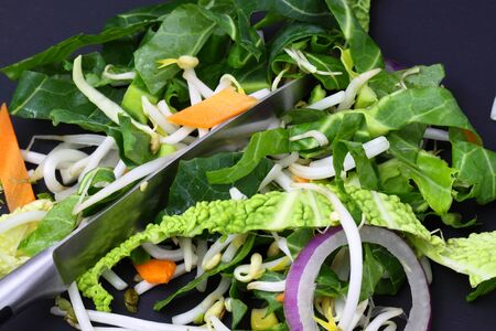 Sliced vegetables prepared for a stir fry on a black wood backgroundの写真素材