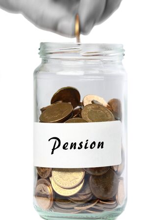 Man adding a coin to a jar of change marked pensionの写真素材