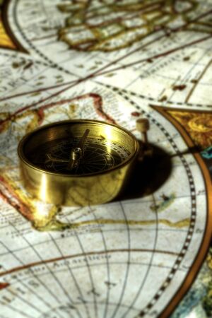 Antique brass compass on an old mapの写真素材