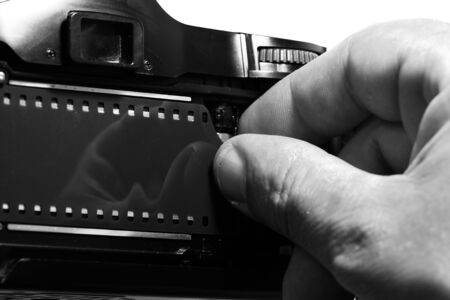 Man loading a vintage retro camera with a strip of filmの写真素材
