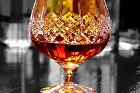 Abstract image of brandy in cut glass with bottles in the backgroundの写真素材