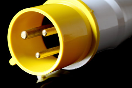 An industrial electric plug on black background.