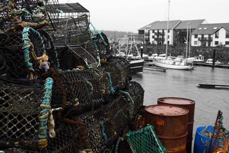 Lobster crab pots stacked on a quayside edited using selective colourの写真素材
