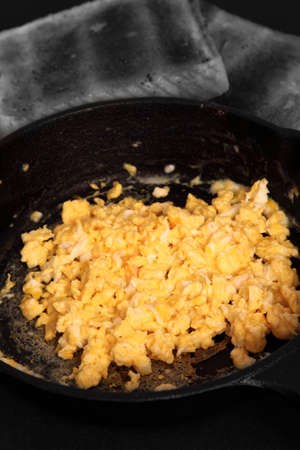 Scrambled egg in a cast iron frying pan with toast.  Edited using selective colorの写真素材