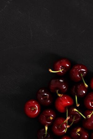 Fresh organic cherries on a black wood backgroundの写真素材