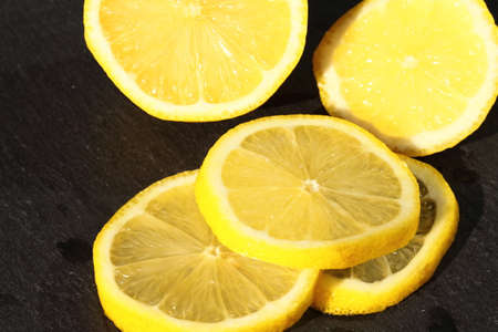 Slices of lemon on a slate background.の写真素材
