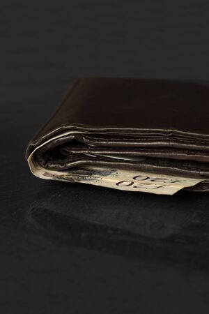 Wallet with twenty pound notes on a table,  with selective colourの写真素材